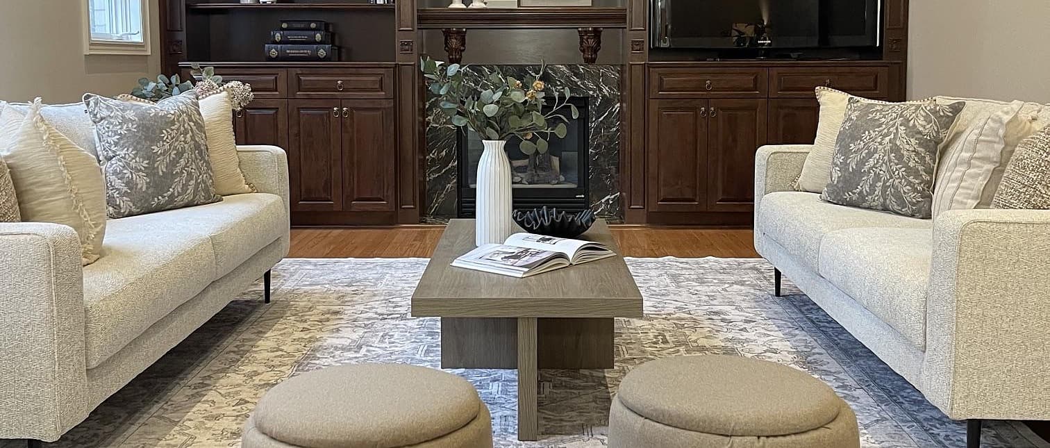 Two cream sofas facing each other beside a styled fireplace with dark wood built-ins