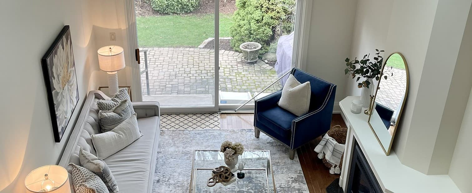 Staged living room with skylights, a navy accent chair, and a mirrored mantel