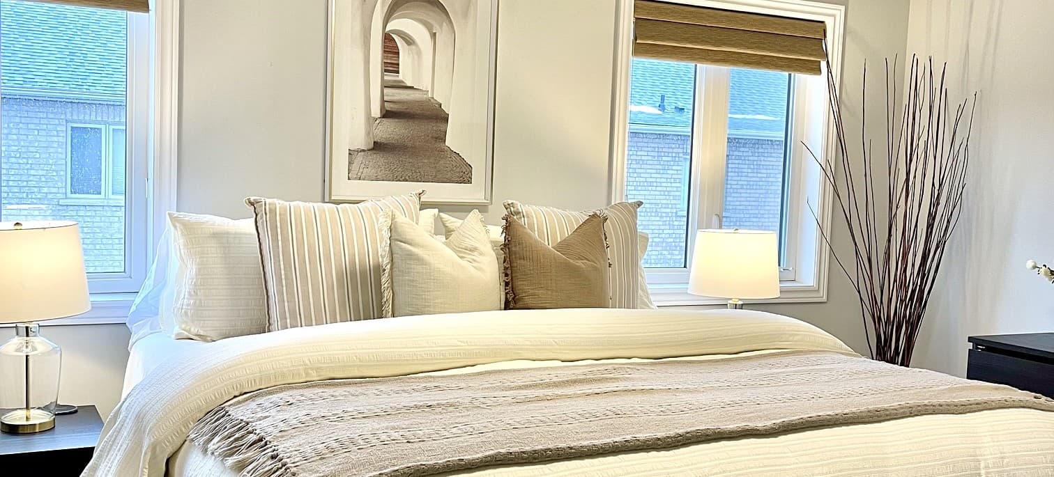 Styled bedroom with layered pillows and warm bedside lighting